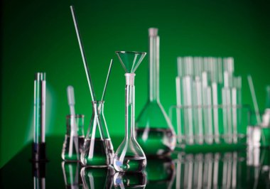 Coronavirus salgını teması. Hızlı covid testleri ve anti-covid aşısıyla ilgili bilimsel araştırma. Laboratuvarda yeşil arka planda deney tüpleri ve deney tüpleri.