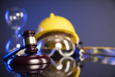 İş hukuku ve gelişen hukuk kavramı. Gavel ve sarı kask parlayan lağım masasında..