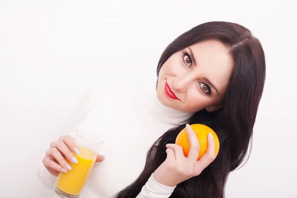 Sporty woman over white background holding glass of orange juice — Stock Photo, Image