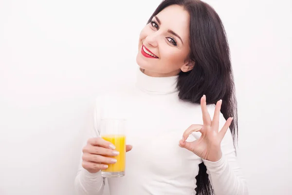 美丽的年轻女子，与一杯果汁和橙色，白色背景上的肖像 — 图库照片