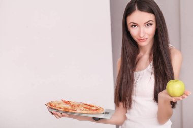 Diyet. Genç güzel kadın sağlıklı yaşam tarzı ve zararlı gıda arasında bir seçimdir. Sağlıklı beslenme ve obezite kavramı. Güzel ince rakam kız