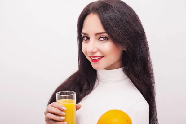 Счастливая улыбающаяся молодая женщина пьет апельсиновый сок — стоковое фото
