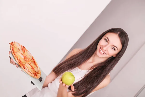 Régime alimentaire. Jeune belle femme fait un choix entre un mode de vie sain et des aliments nocifs. Le concept de saine alimentation et l'obésité. Belle silhouette mince fille — Photo