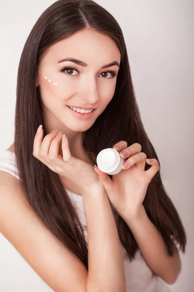 Cura della pelle. Bella giovane donna sana con i capelli lunghi, prendersi cura della loro pelle. Utilizzare la crema per la cura del corpo. Bellezza e salute — Foto Stock