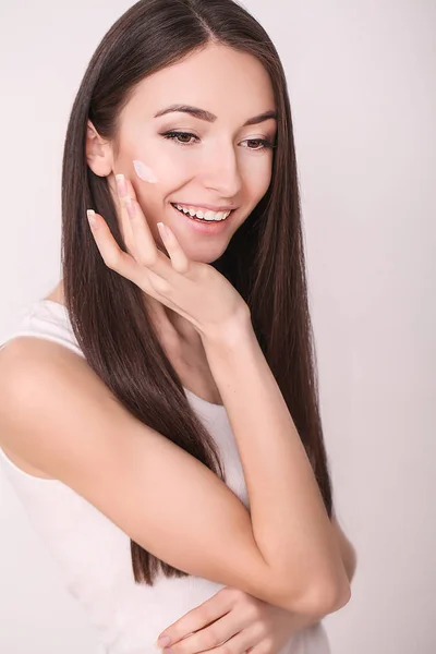 Kozmetikai krém alkalmazása. Egy gyönyörű fiatal nő alkalmazása arc hidratáló. Az arc és a kéz Scine — Stock Fotó