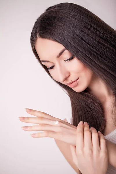 Gesichtsbehandlung. Frau im Schönheitssalon. Anwendung kosmetischer Creme. eine schöne junge Frau, die Gesichtsfeuchtigkeitscreme aufträgt. Pflegen des Gesichts und der Hände — Stockfoto