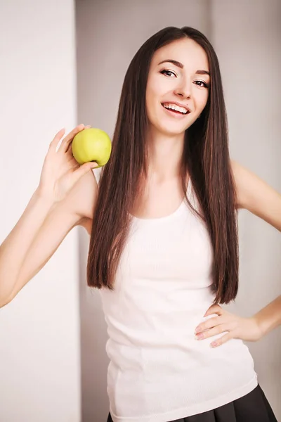 Dieta. Uma jovem observa sua figura e come frutas frescas. O conceito de alimentação saudável . — Fotografia de Stock