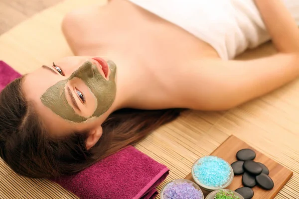 Conceito de beleza e spa - mulher feliz no salão de spa deitado na mesa de massagem — Fotografia de Stock