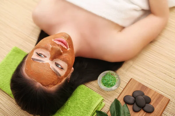 Persone, bellezza, spa, cosmetologia e concetto di cura della pelle - primo piano di bella giovane donna sdraiata con gli occhi chiusi e cosmetologo applicare la maschera facciale a pennello in spa — Foto Stock