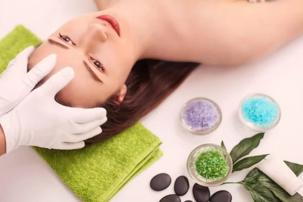 Persone, bellezza, spa, cosmetologia e concetto di cura della pelle - primo piano di bella giovane donna sdraiata con gli occhi chiusi e cosmetologo applicare la maschera facciale a pennello in spa — Foto Stock