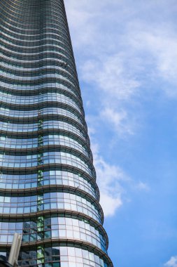 açı bakış açısı ve alt görüntülemek için modern Cam bina gökdelenlerin dokulu arka plan üzerinde bulutlu gökyüzü mavi