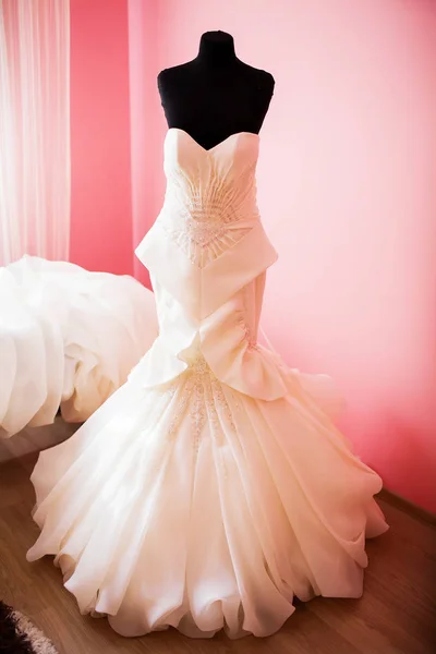 Trouwjurk opknoping op een mannequin in een kamer van de bruid op haar trouwdag — Stockfoto