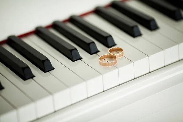 Yakın çekim piyano klavye üzerinde iki güzel alyans — Stok fotoğraf