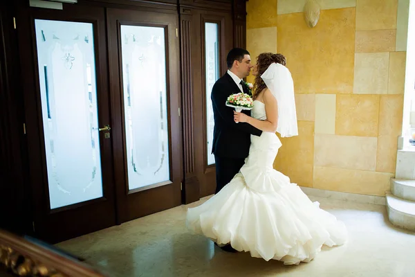 Noiva e noivo beijando em um interior elegante — Fotografia de Stock