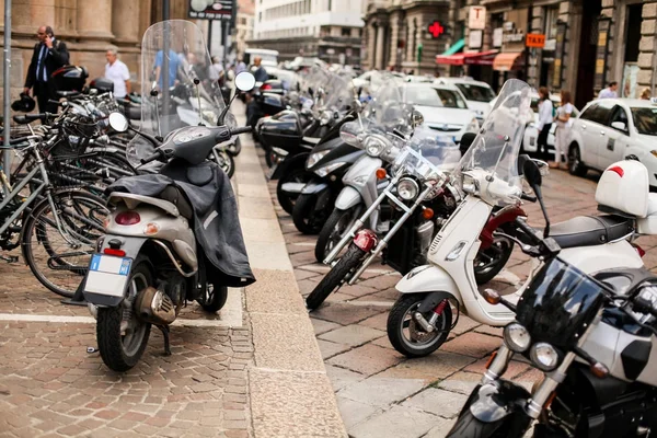 Motorbike, motorcycle scooters parked in row in city street. Close up of wheel