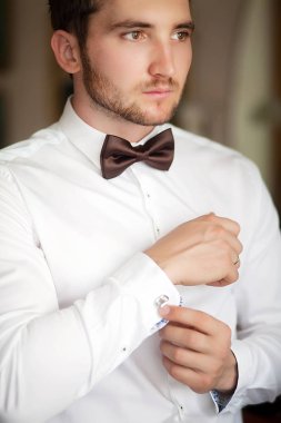 Yakışıklı adam sabah odasına pencereden yakınındaki gömlek ayakta koyarak. Bazı olay ya da yeni iş günü için hazırlanıyor. Yeni fırsatlar, dating, gün düğün veya iş için hazırlanıyor konsepti röportaj