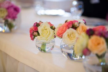 yemek masası üzerinde cam vazoda çiçek buketi