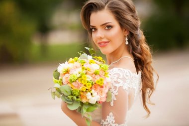 Büyük düğün buket tutan gelin gülümseyen