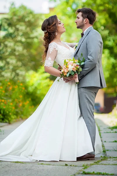 Casal de casamento. Bela noiva e noivo. Acabei de casar. Fecha. Noiva feliz e noivo em seu abraço de casamento. O noivo e a noiva num parque. Vestido de noiva. Casamento nupcial — Fotografia de Stock