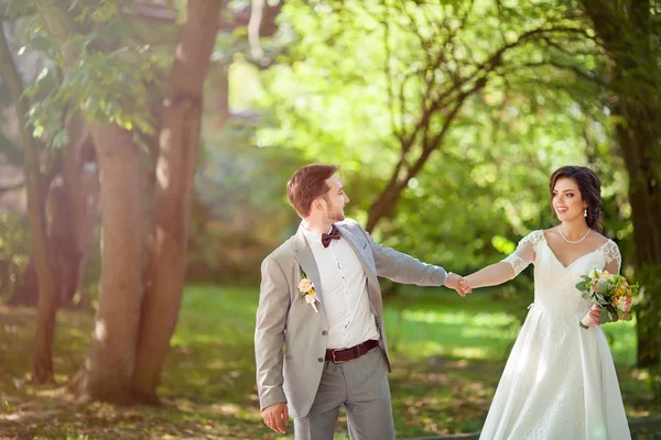 Bride and groom in a park kissing.couple newlyweds bride and groom at a wedding in nature green forest are kissing photo portrait. — Stock Photo, Image
