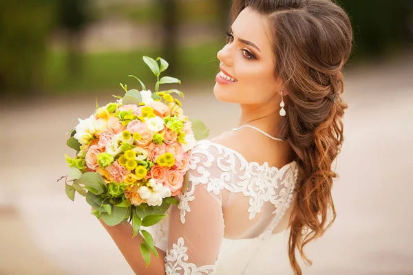 Büyük düğün buket tutan gelin gülümseyen