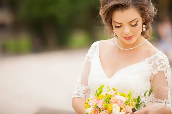 Retrato de joven hermosa novia atractiva con flores. Vestido blanco y decoraciones de boda . — Foto de Stock