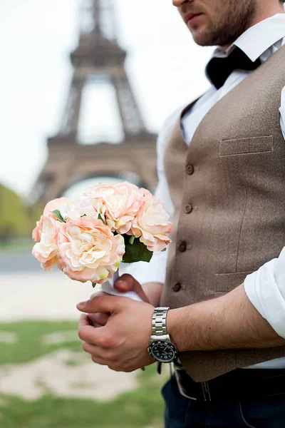 Bruidegom houdt een bruiloft boeket van witte rozen. — Stockfoto