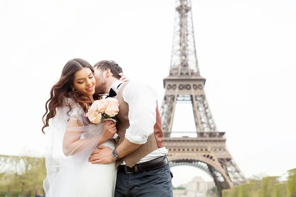 Bruiloft in Parijs. gelukkig net getrouwd paar knuffelen in de buurt van de Eiffeltoren — Stockfoto
