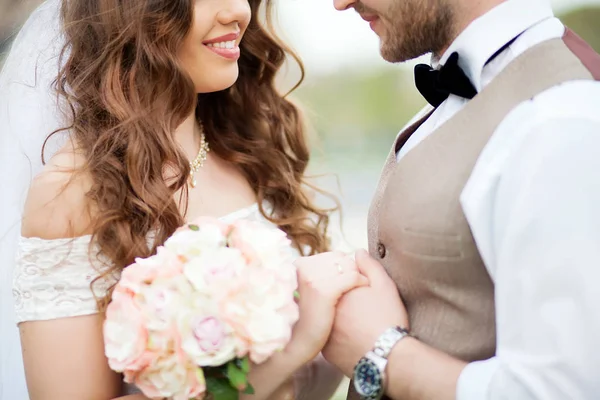 Luva e noiva segurando buquê de rosas minúsculas — Fotografia de Stock
