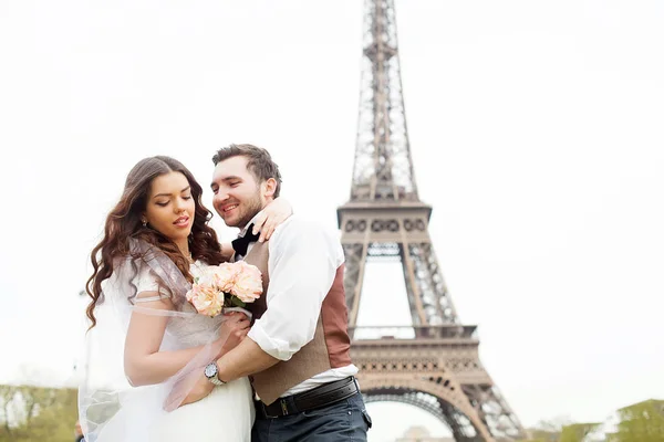 Young loving couple in Paris, holding hands near the Eiffel tower