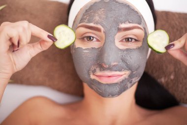 Güzel ve genç birbayan Spa'da, salatalık gözleri ile yalan yüz kil maskesi oluyor