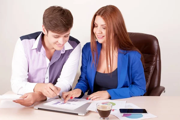 Dos jóvenes felices sonriendo exitosos empresarios trabajando con documento o contrato en la oficina — Foto de Stock