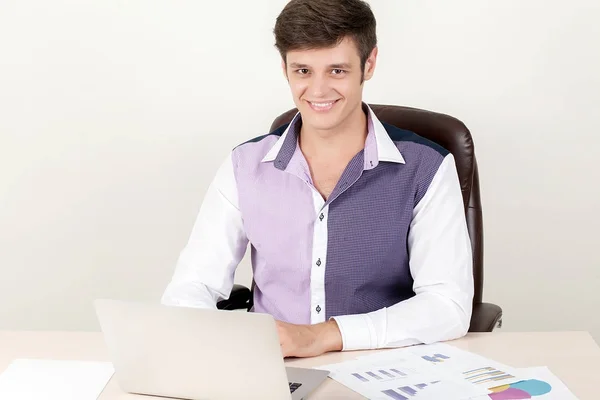 Porträtt av ung affärsman sitter på kontoret och använder sin bärbara dator medan du arbetar på nytt projekt. — Stockfoto