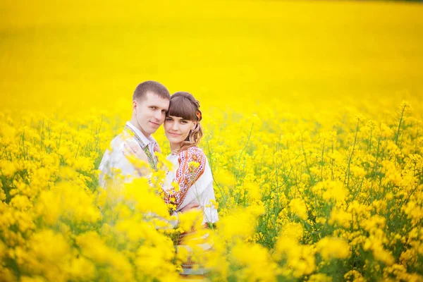 Sposa e sposo luce del sole all'aperto in piedi in un abbraccio campo giallo , — Foto Stock