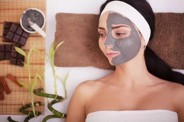 Mujer hermosa joven con máscara facial, tratamiento de spa — Foto de Stock
