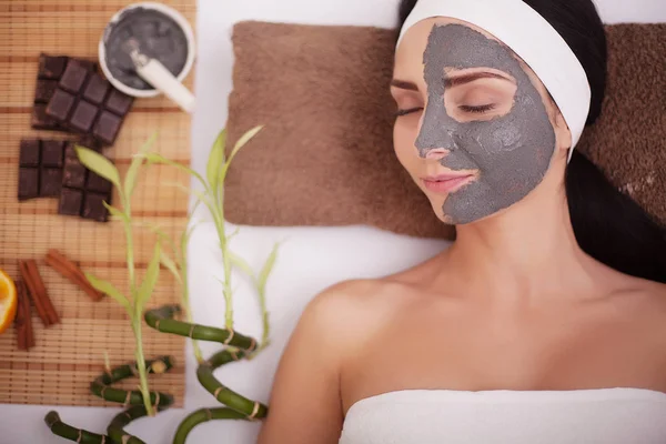 Mujer joven en salón de belleza con mascarilla facial — Foto de Stock