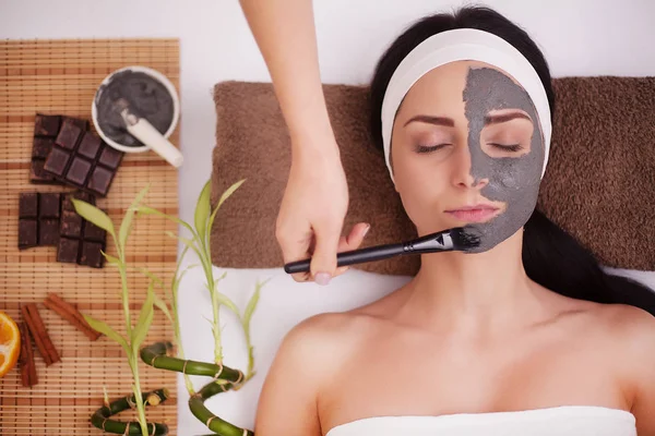 Zastosowanie twarzy maski na twarz kobiety w salonie kosmetycznym — Zdjęcie stockowe
