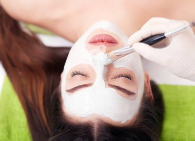 Spa konsepti. Güzellik salonunda besin maskesi takan genç bir kadın.