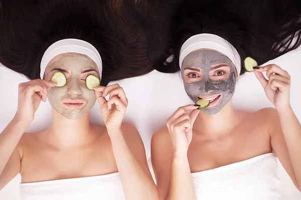 Las niñas en un tratamiento de belleza con rodajas de pepino — Foto de Stock