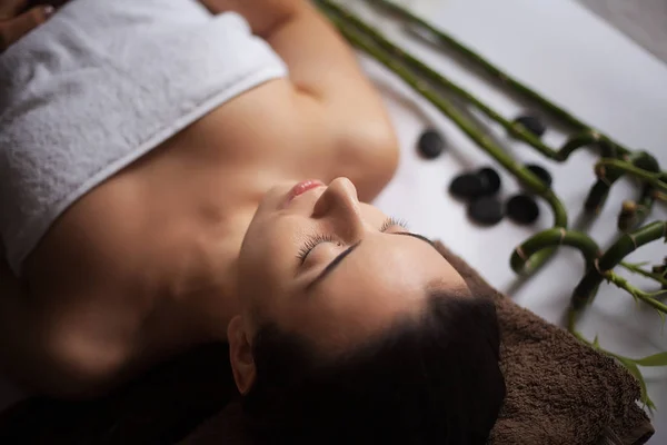 Imagen de la mujer en el salón de spa tumbada en el escritorio de masaje — Foto de Stock