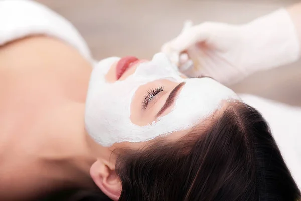 Konsep spa. Menerapkan tangan masker bergizi pada wajah perempuan di spa salon — Stok Foto
