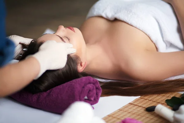 Bella ragazza con massaggio facciale nel salone spa — Foto Stock
