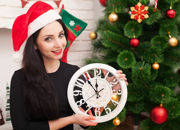 Menina bonito em santa chapéu com árvore de natal decorada e relógio velho — Fotografia de Stock