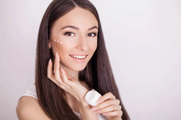 Concepto cuidado de la piel. Una mujer joven y saludable con crema cosmética — Foto de Stock