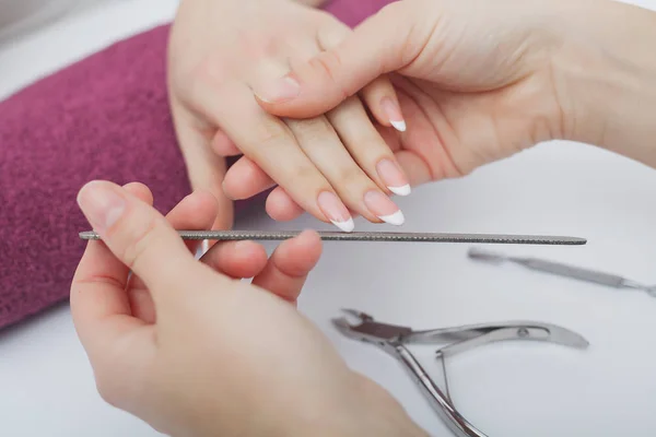 Mujer manos en un salón de uñas recibiendo un procedimiento de manicura. SPA —  Fotos de Stock