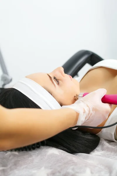 Cosmético realizando fotorejuvenecimiento procedimiento de cosmetología para una mujer — Foto de Stock