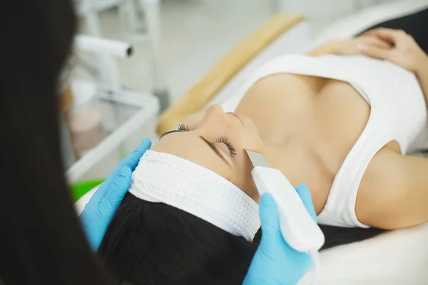 Verjongende gezichtsbehandeling. Model krijgen opheffing van therapie massage in de Spa beautysalon. Afschilfering, verjonging en hydratatie. Model en arts. Cosmetologie. — Stockfoto