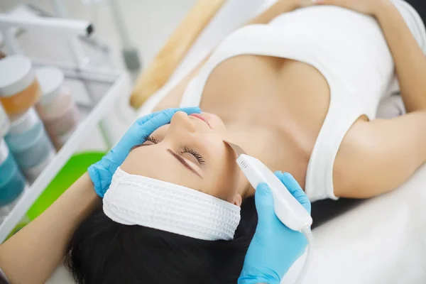 Mujer recibiendo descamación facial eléctrica en salón de belleza europeo . — Foto de Stock