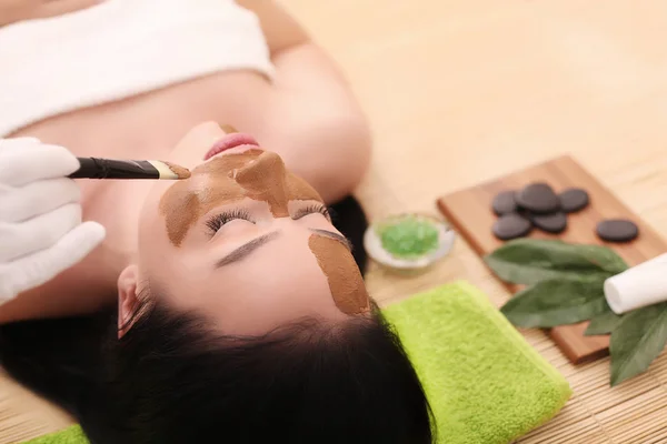 Terapia de spa de mulher jovem que tem máscara cosmética no salão de beleza — Fotografia de Stock