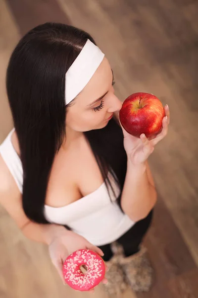 Dieta. Concepto de dieta. Comida saludable. Hermosa joven mujer elegir entre frutas y dulces —  Fotos de Stock